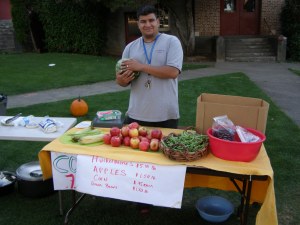 Gabriel Muro, NCS Health Promoter, models how to sell vegetables at a Farmers Market